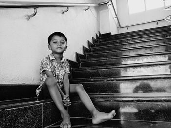 Full length of boy sitting on staircase