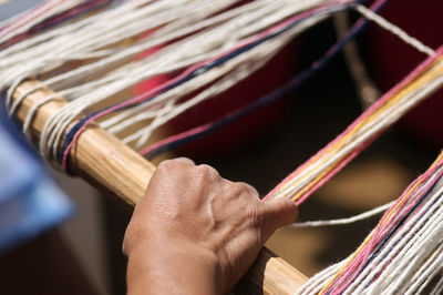 Cropped image of person working at handloom