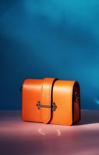 Orange color bag in front of blue background