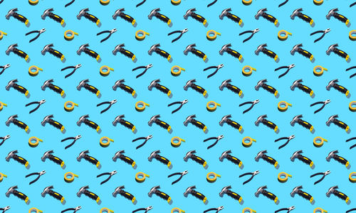 Hammers, pliers, and duct tape on a blue background, pattern, hard shadows. 