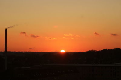 Silhouette city against sky during sunset