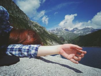 Midsection of woman and mountains against sky