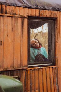 Portrait of woman looking through window