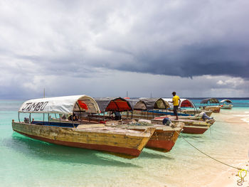 Boats moored on beach against sky