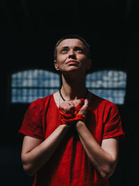 Portrait of young woman standing against wall