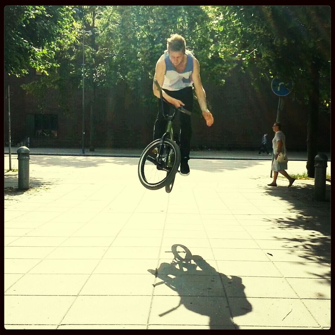 transfer print, full length, lifestyles, leisure activity, auto post production filter, casual clothing, young adult, tree, shadow, bicycle, person, childhood, sunlight, men, street, side view, enjoyment