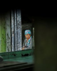 Rear view of woman looking through window