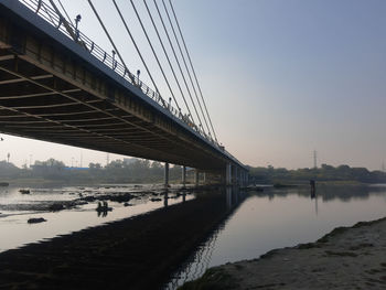 Bridge over river against sky during sunset