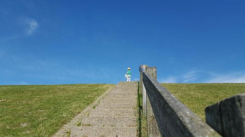 Low angle view of person standing on steps against sky