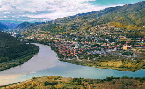 High angle view of townscape by mountain against sky