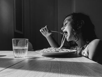 Midsection of girl eating pasta