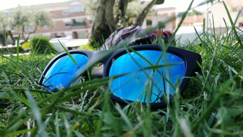Surface level of blue car on grassy field