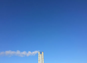 Low angle view of factory against blue sky