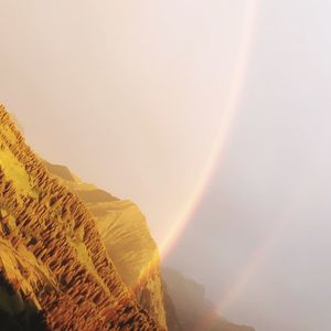 Low angle view of rainbow over mountain against sky