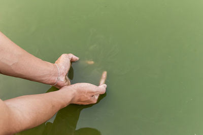 Cropped hands in lake