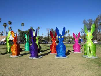 Panoramic shot of multi colored umbrellas against blue sky