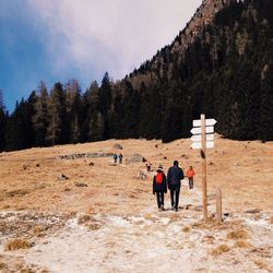 People standing on mountain road against sky