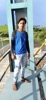 Portrait of boy standing on railing