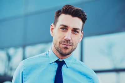 Portrait of young man against blue background