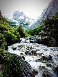 Scenic view of waterfall in forest against clear sky