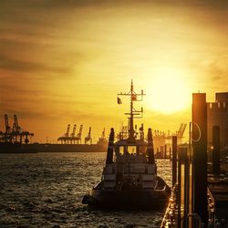 Silhouette of cranes at harbor during sunset