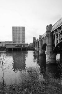 Bridge over river against buildings in city