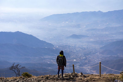 Rear view of woman standing on mountain