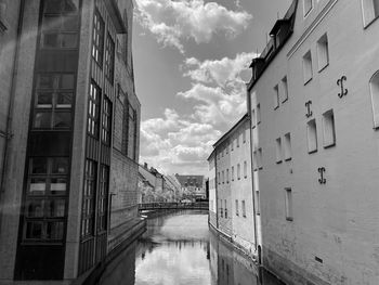 Canal amidst buildings against sky