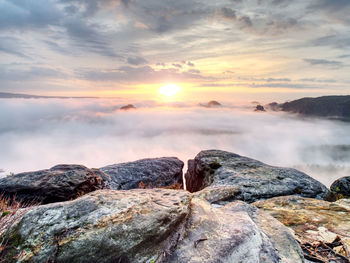 Rocks on the edge of a mountain. foggy mountain in the far distance. beautiful misty landscape