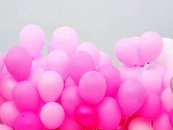 Low angle view of pink balloons against sky