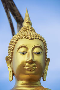 Low angle view of buddha statue against sky