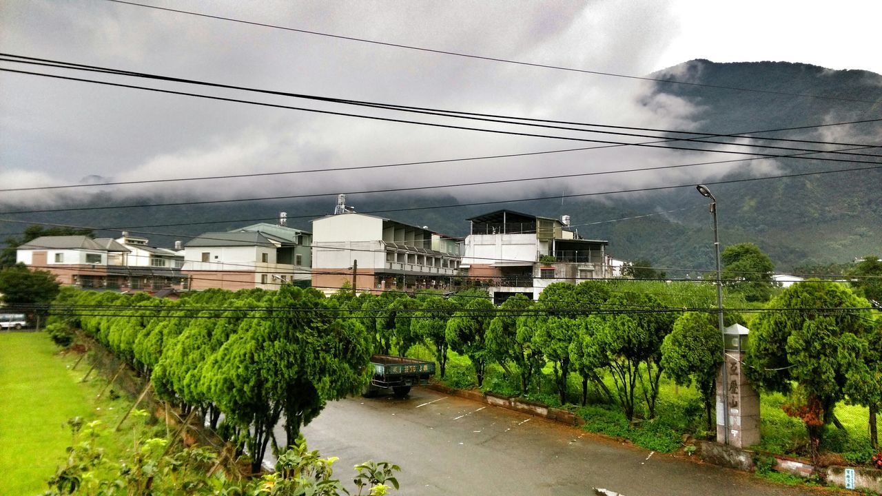 sky, building exterior, built structure, architecture, cloud - sky, cloudy, road, house, transportation, green color, grass, tree, street, cloud, car, nature, weather, day, field, overcast