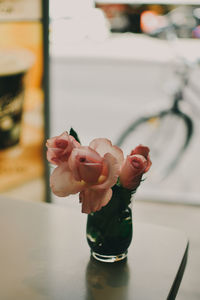 Close-up of hand holding glass vase on table