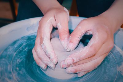 Cropped hands of person making pot