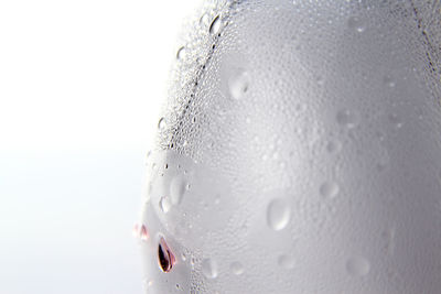 Close-up of wet glass against white background