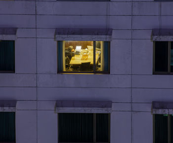 Reflection of building on glass window at night