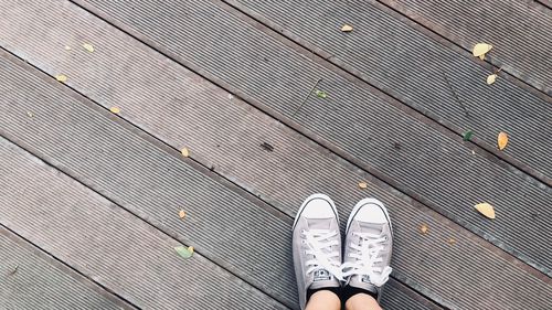 Low section of person standing on boardwalk