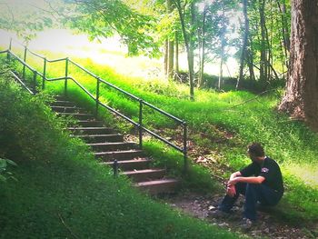 Man sitting on staircase in forest