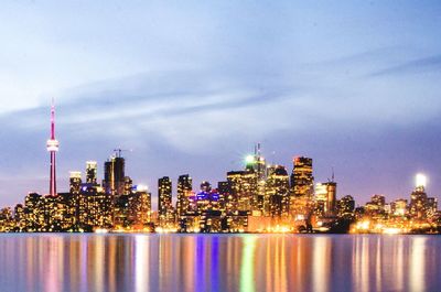 Illuminated buildings in city against sky