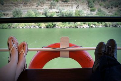 Low section of people relaxing in boat on lake