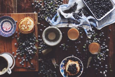 Directly above shot of blueberries and pancakes with tea on table