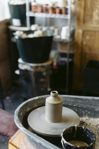 Midsection of person preparing coffee in cup on table