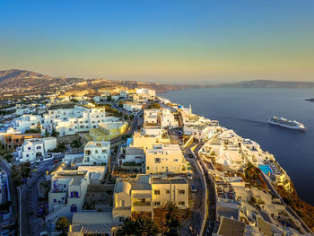 High angle view of townscape by sea against clear sky