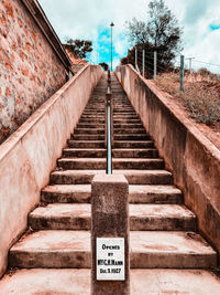 Information sign on staircase against sky