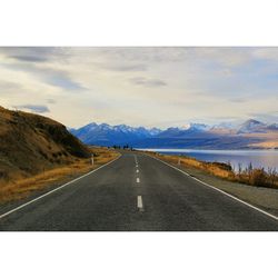 Empty road with mountains in background