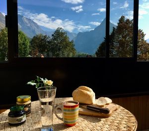 Breakfast on table by window against mountains