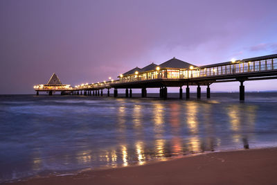 Illuminated bridge over river at night