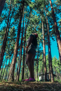 Low angle view of woman standing in forest