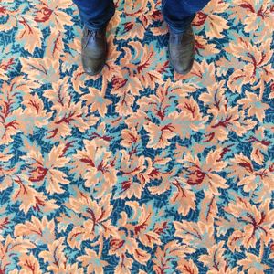 Low section of man standing on patterned carpet