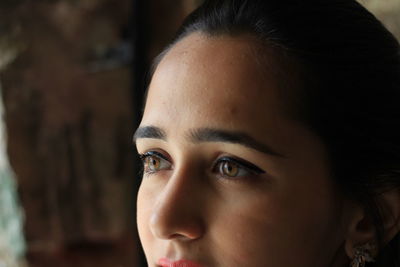 Close-up portrait of beautiful young woman looking away